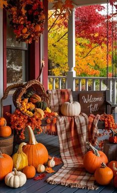 a porch decorated with pumpkins, gourds and other autumn decorating items