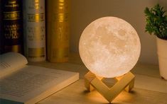 the moon lamp is sitting on top of a book