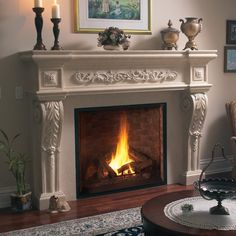 a living room with a fire place in the center and pictures on the wall above it