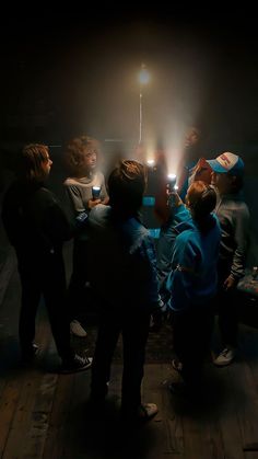 a group of people standing next to each other in front of a light on a pole