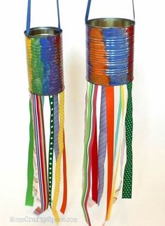 two tin cans with colorful ribbons hanging from the sides and one has a handle on each side