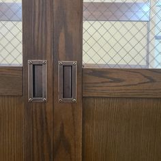 two wooden doors with metal handles on each side