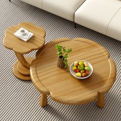 a small table with fruit on it in front of a white couch and coffee table