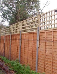 a wooden fence next to a brick building with a sign that says the garden shop