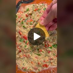 a person is scooping some food into a large bowl with a tortilla chip