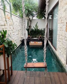 an indoor swimming pool with two swings in the middle