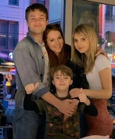 a family posing for a photo in front of a window