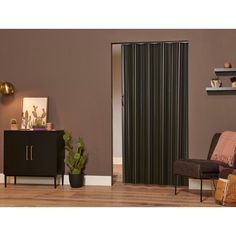 a living room with brown walls and black vertical blinds on the sliding glass doors that open up to let in natural light