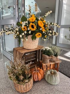 sunflowers and gourds are arranged in baskets on top of wooden crates