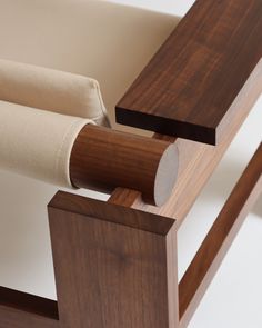 a close up of a wooden bench with fabric on the armrests and back