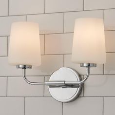 two light bathroom fixture in chrome finish with white glass shades on brick wall behind it