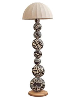 a lamp that is sitting on top of a wooden base and has zebra print balls in it