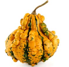 a gourd filled with lots of yellow and green fruits on top of each other