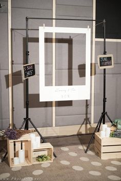 the photo booth is set up in front of a wall with two frames and three candles