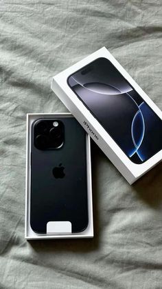 an apple iphone 11 pro in its box on a bed with the packaging removed from it