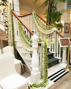 the stairs are decorated with white flowers and greenery