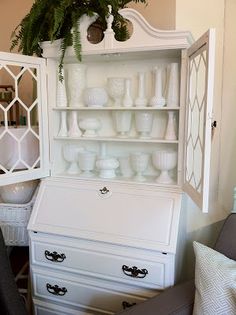 a white china cabinet with glass doors and drawers