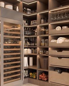 a kitchen pantry filled with lots of food and wine bottles in it's shelves