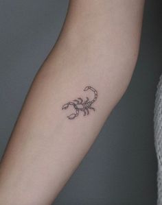 a small scorpion tattoo on the arm