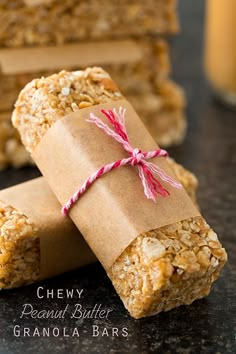 homemade granola bars wrapped in brown paper and tied with twine on black surface