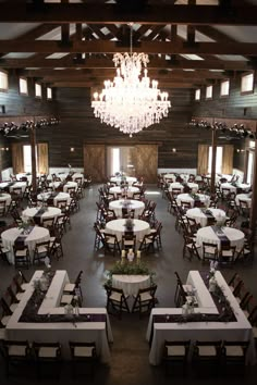 an empty dining room with chandelier and tables set up for formal function or party