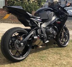 a black motorcycle parked on top of a grass covered field