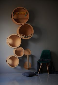 there are many wooden bowls hanging on the wall next to a chair and a green chair