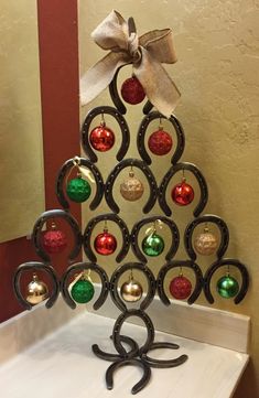 a metal christmas tree with ornaments on it