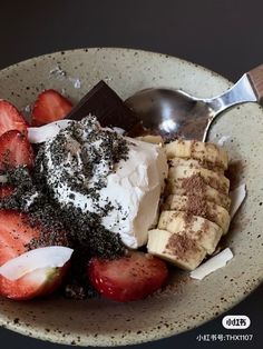 a bowl filled with strawberries, bananas and other toppings next to a spoon