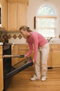 a woman is cleaning the oven in her kitchen