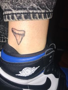 a person with a small tattoo on their foot and a blue band around the ankle