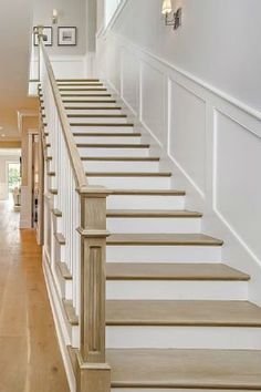 the stairs in this house are made of wood and white with beige railings on each side