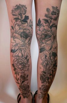 a woman's legs with tattoos and flowers on them