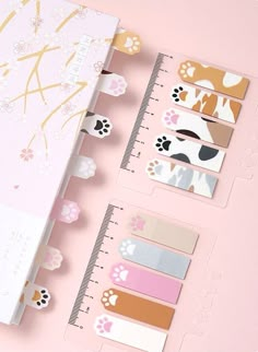 a pink notebook with stickers on it next to a ruler and flowered paper