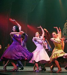 a group of people that are standing on a stage with their arms in the air