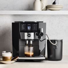 an espresso machine sitting on top of a counter next to a cup of coffee