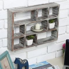 an old wooden shelf with plants and pictures on it