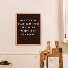 a wooden cutting board sitting on top of a kitchen counter next to a white wall