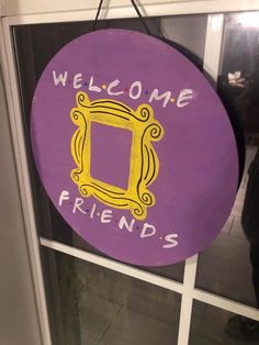 a purple welcome sign hanging from the side of a glass door that says, welcome friends