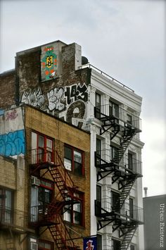 a fire escape on the side of an apartment building with graffiti all over it's walls