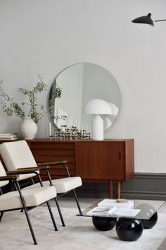 a living room filled with furniture and a large mirror