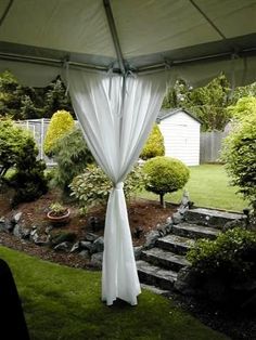 an open umbrella in the middle of a yard with steps leading up to trees and bushes