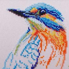 a close up of a colorful bird on a white background with bead work in the middle