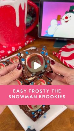 someone is holding some frosted brownies in front of a computer screen with the words easy frosty the snowman cookies on it