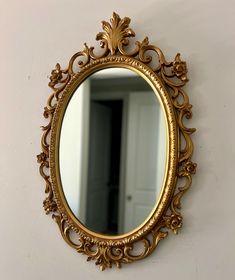 an ornate gold mirror hanging on the wall