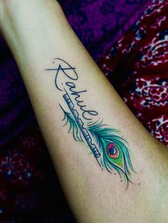 a woman's arm with a feather tattoo on it