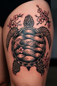 a woman's thigh with a turtle and flowers on it