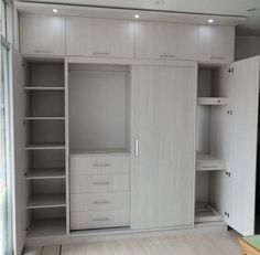 an empty room with white cabinets and drawers