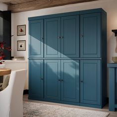 a kitchen with blue cabinets and white chairs