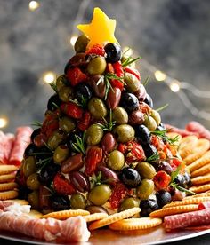 a christmas tree made out of olives, cheese and crackers on a plate